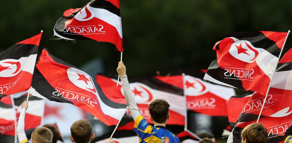 Saracens supporters hold their flags