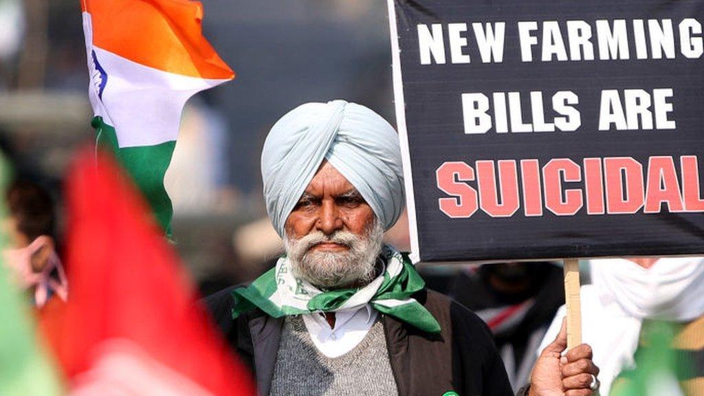 Farmer at protest holding banner