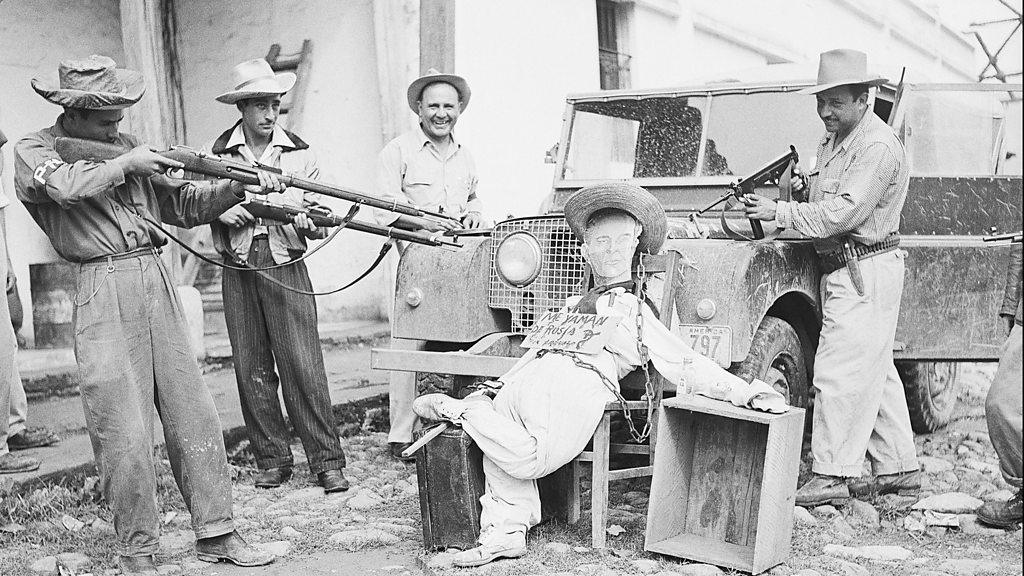 Soldiers point gun at an effigy of the president