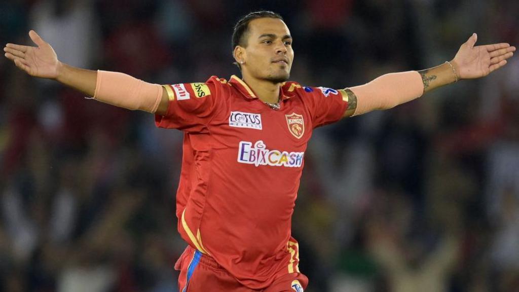 Rahul Chahar celebrates taking a wicket for Punjab Kings in the Indian Premier League, rising his arms outwards either side