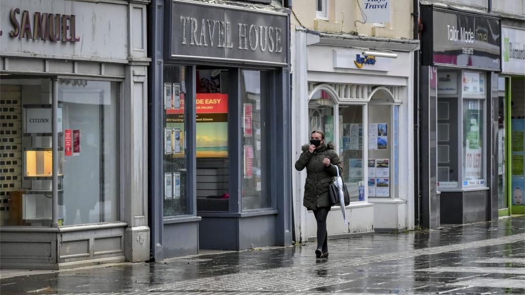 A woman wearing a facemask while walking through Bridgend town centre