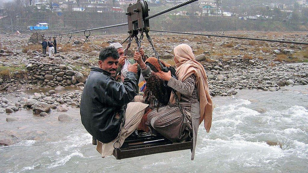 Pakistani's sit on a makeshift cable car to cross a river to get to their home in 2007