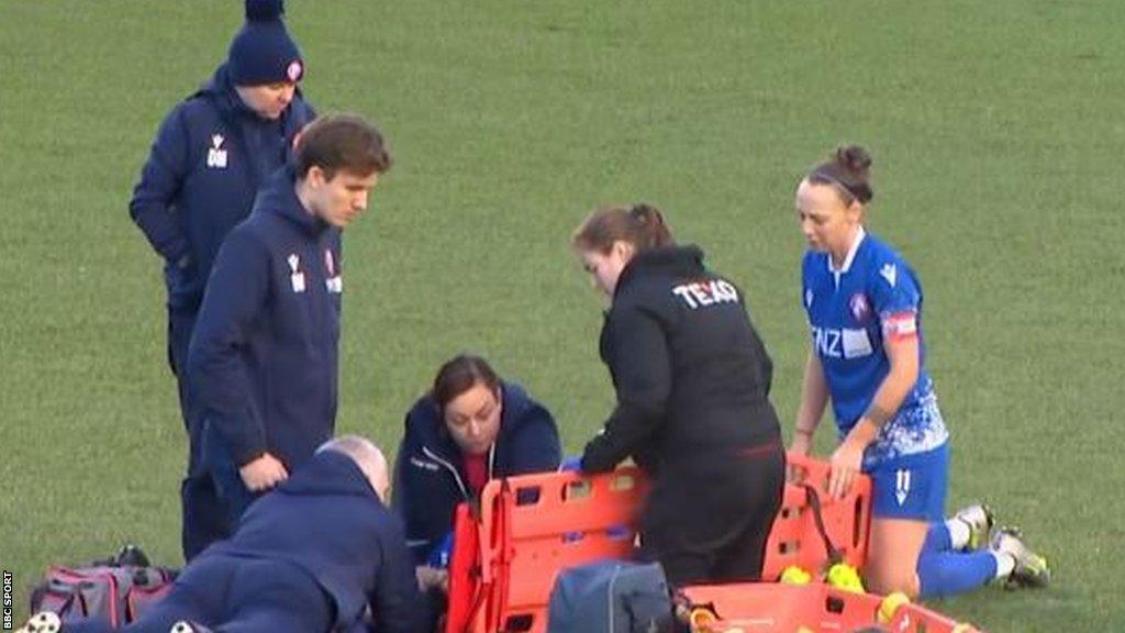 Becky Galbraith (obscured) receives treatment for a neck injury