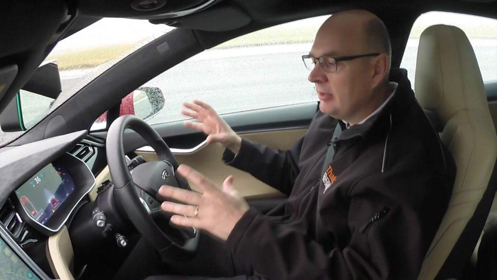 A man sits in a driverless car