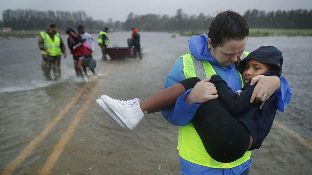 an emergency worker carries a child