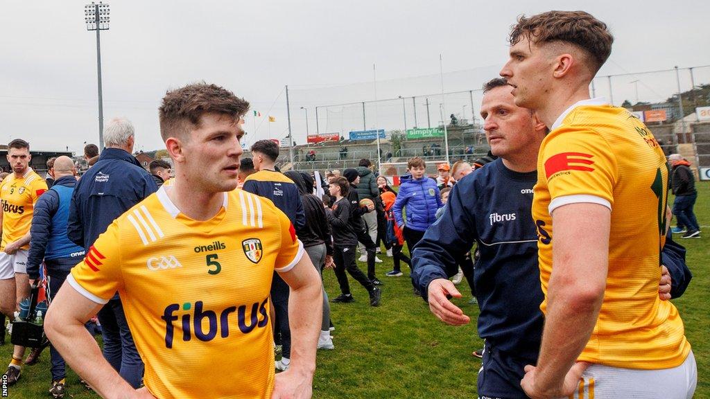 Antrim players and Andy McEntee dejected after the defeat by Armagh