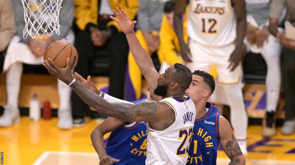 LeBron James drives to the basket to score his 40,000th regular-season point