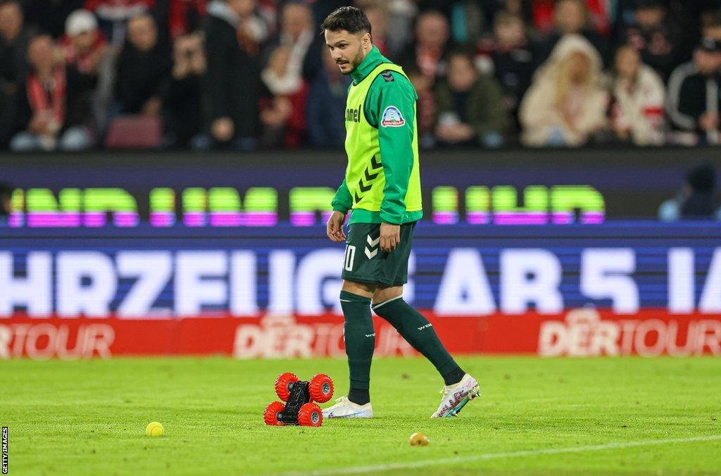 Remote control cars and tennis balls on the pitch at the Cologne-Werder Bremen game