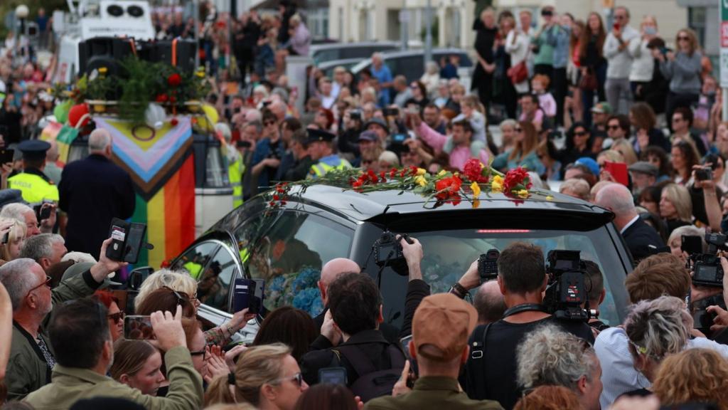 Fans of singer Sinead O'Connor line the streets for a "last goodbye" to the Irish singer as her funeral cortege passes through her former hometown of Bray, Co Wicklow