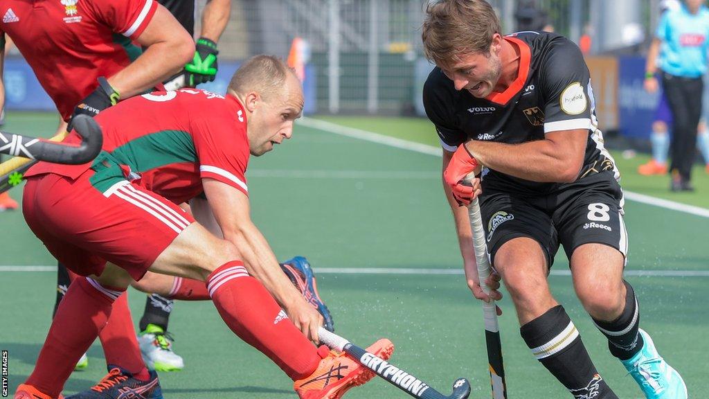 Luke Hawker of Wales battles for possession with Paul-Philipp Kaufmann of Germany during the Euro Hockey Championships