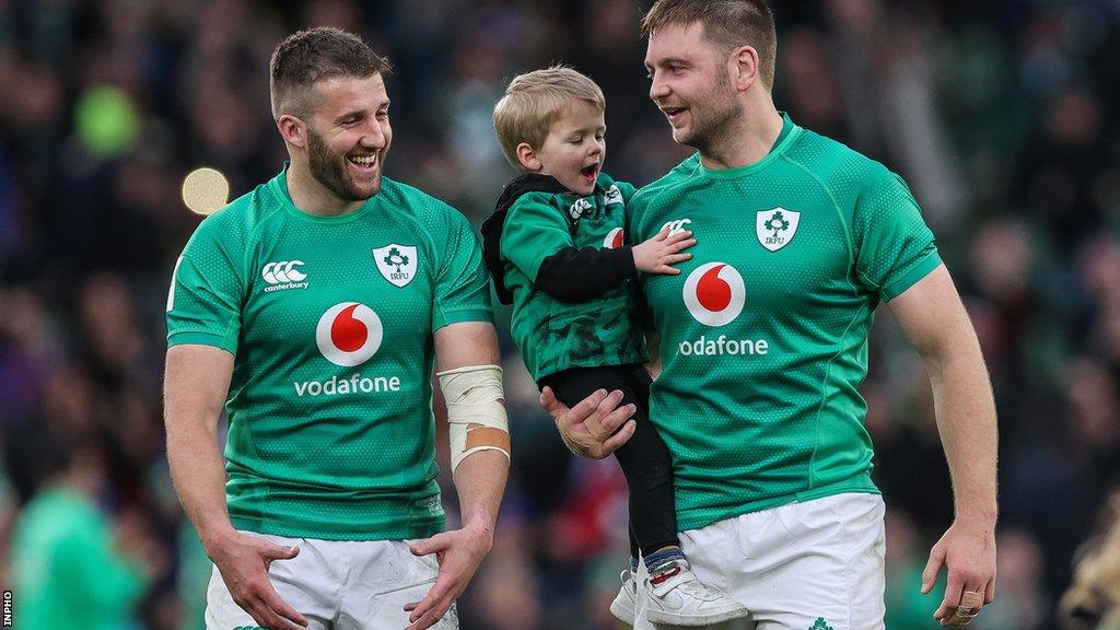 Iain Henderson holds his young son as he talks to Ireland and Ulster team-mate Stuart McCloskey after Saturday's win over France