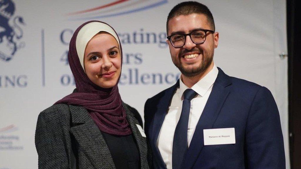 Dr Al Rayyes and his wife pose for a photo in front of a Chevening branded backdrop