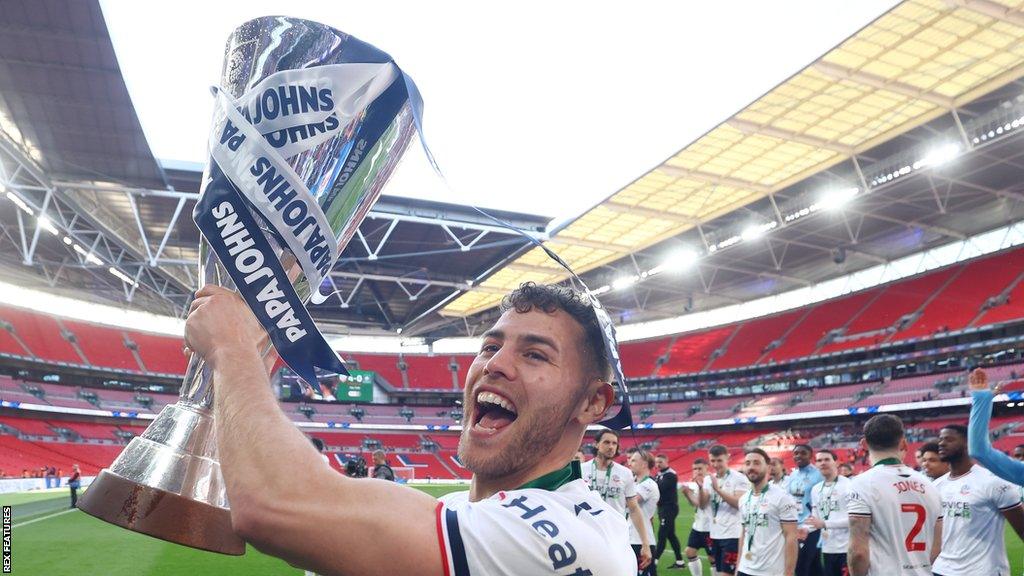 Dion Charles holds the Papa Johns Trophy aloft after Bolton's victory at Wembley last spring