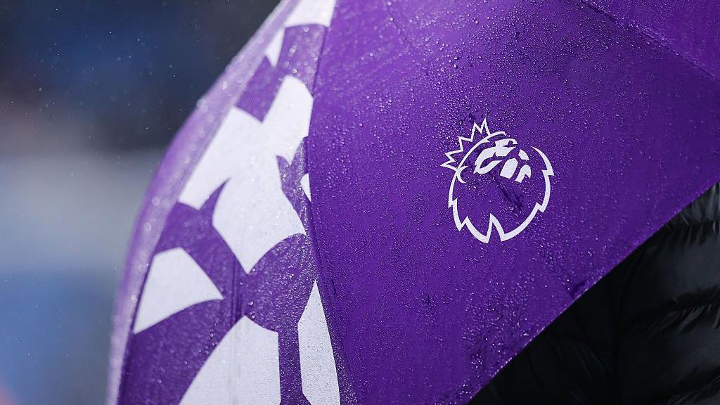 The logo / badge of the Premier League is seen on an umbrella
