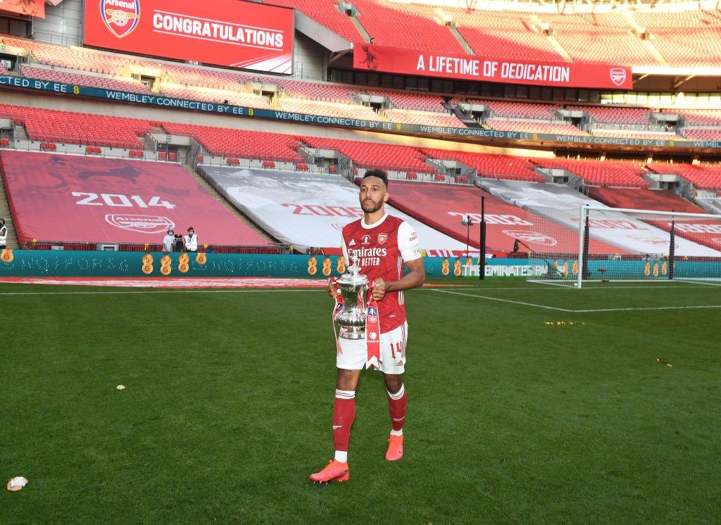 Pierre-Emerick Aubameyang celebrates Arsenal winning the FA Cup Final in an empty wembley stadium.