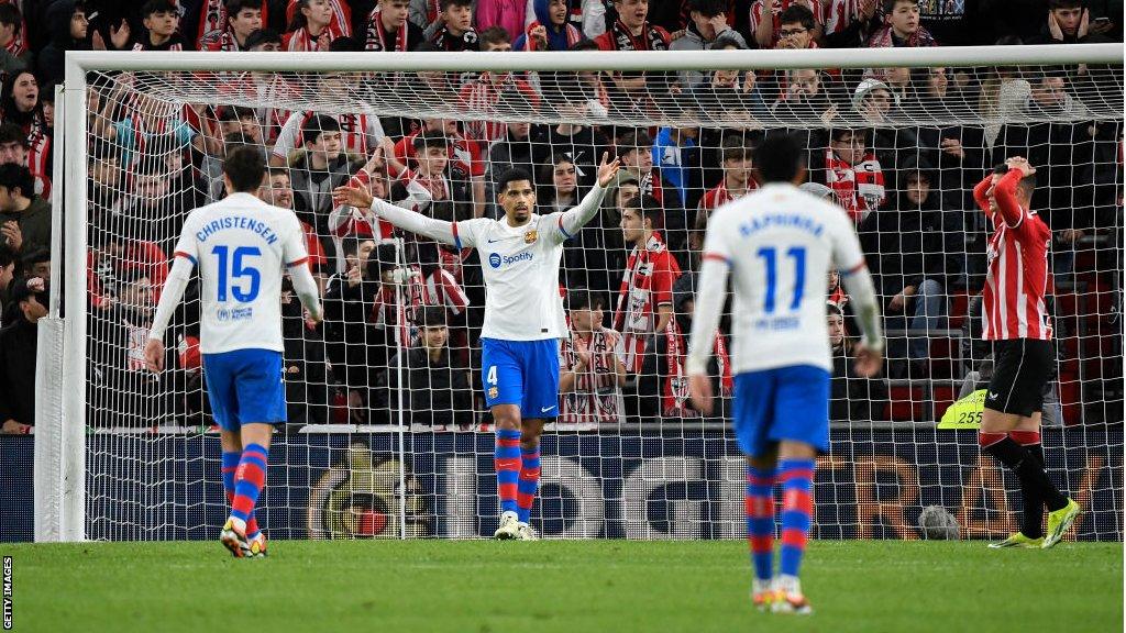 Barcelona defender Ronal Araujo puts his arms up in the air