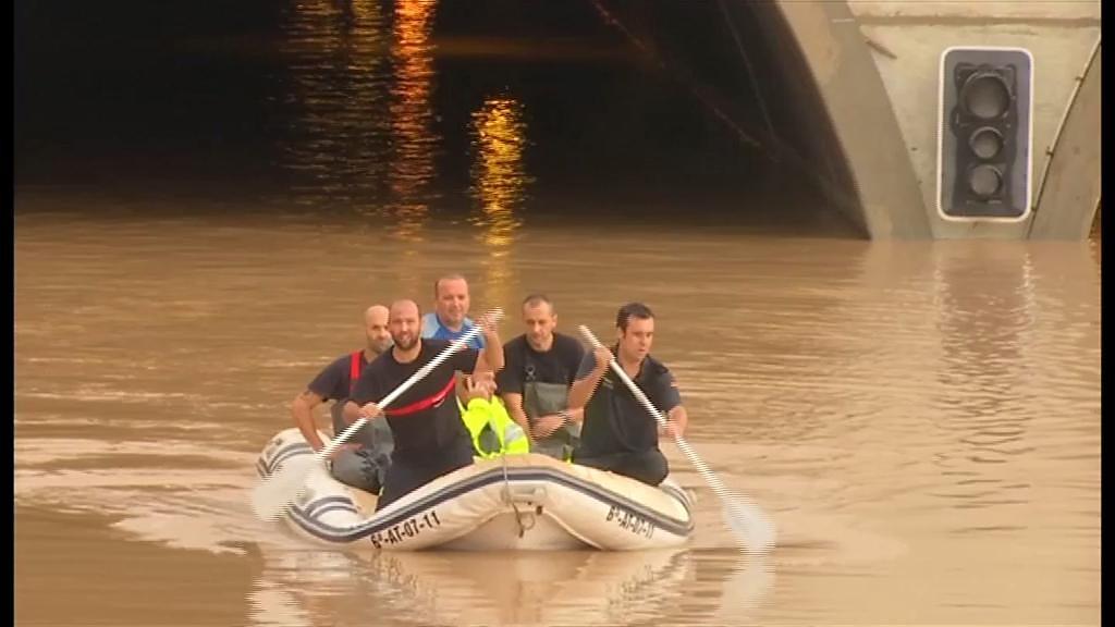 A rescue boat emerges from a road tunnel