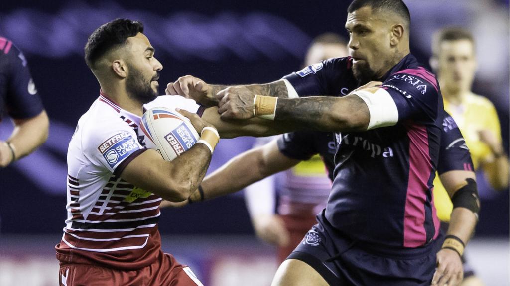 Wigan's Bevan French fends off Hull FC's Manu Ma'u