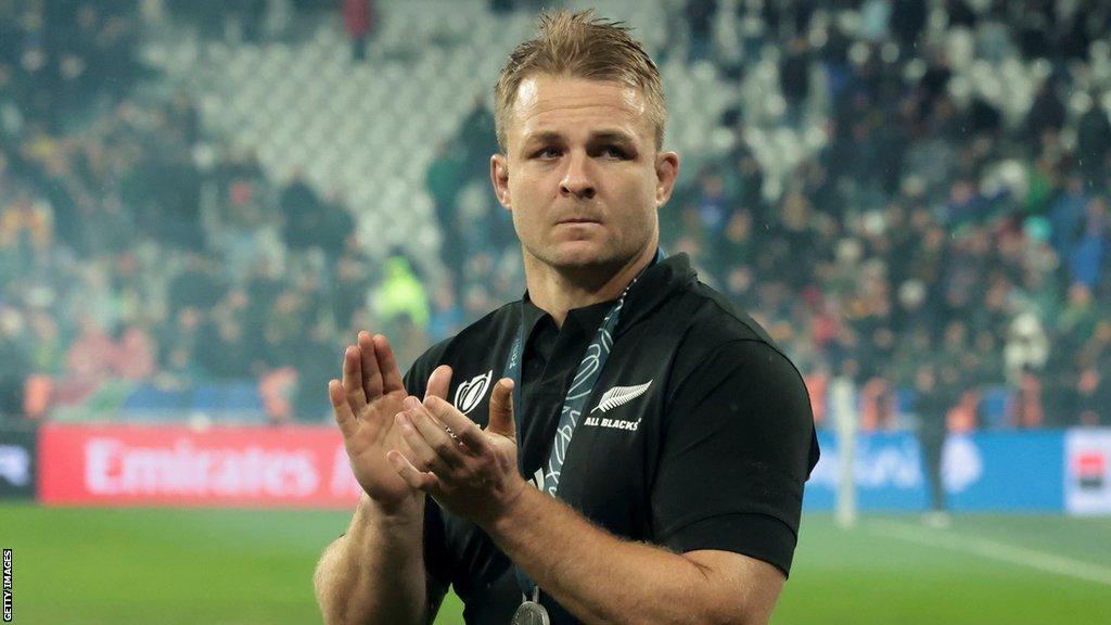 Sam Cane applauds fans while wearing his runner-up medal after New Zealand's World Cup final loss to South Africa