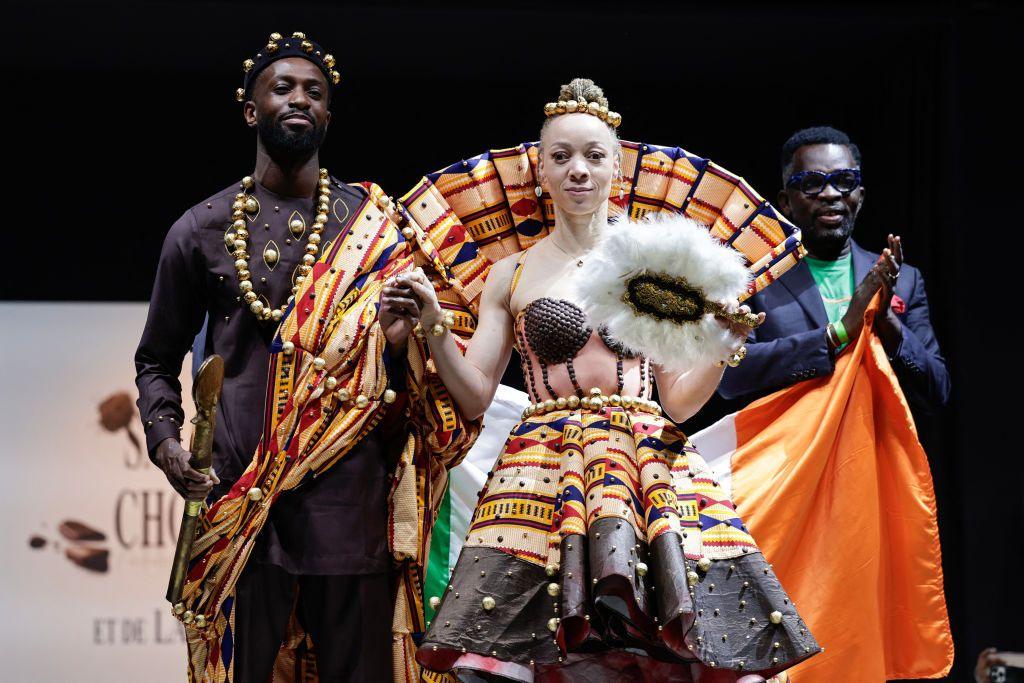 Ivorian designer Roger Bango (R) acknowledges the applause after France's Paris 2024 Paralympic flag bearer Nantenin Keita (2nd R) presenting a model created by him during the chocolate dress parade of the opening day of the Salon du Chocolat de Paris 2024 (2024 Paris Chocolate Fair) in Paris.