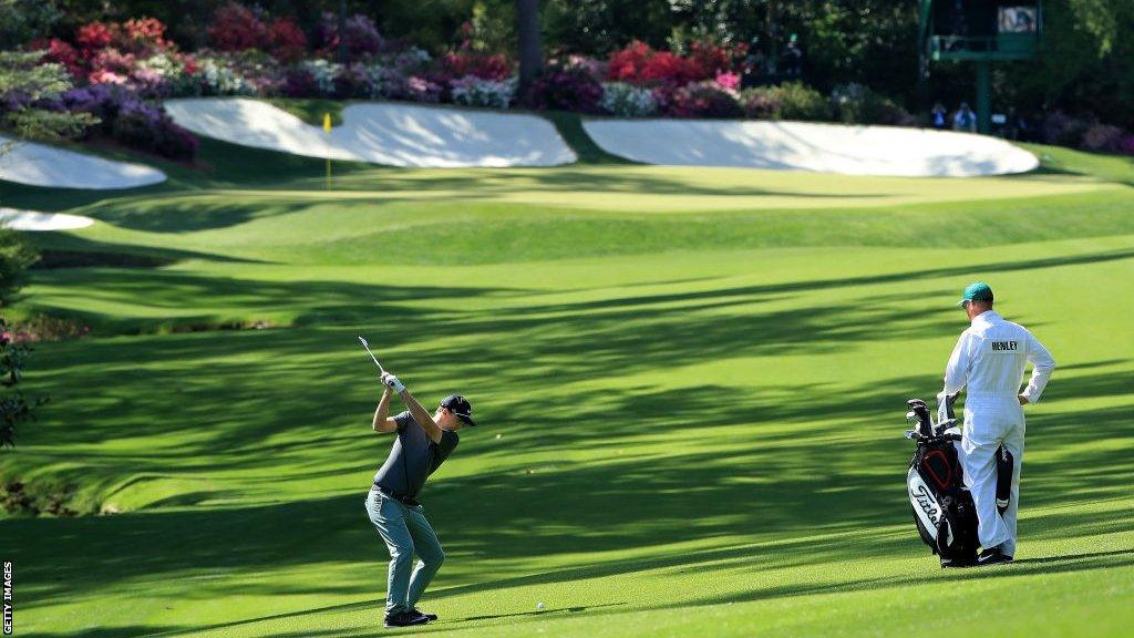 Russell Henley of the United States hits his second shot to the 13th green at the 2018 Masters