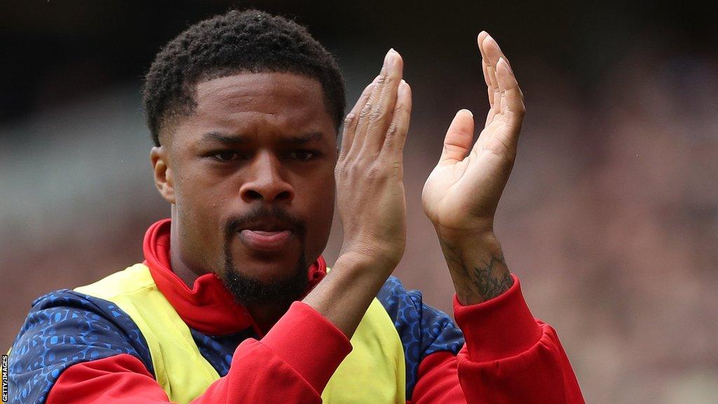 Chuba Akpom applauds fans as he warms up before Middlesbrough's season opener with Millwall