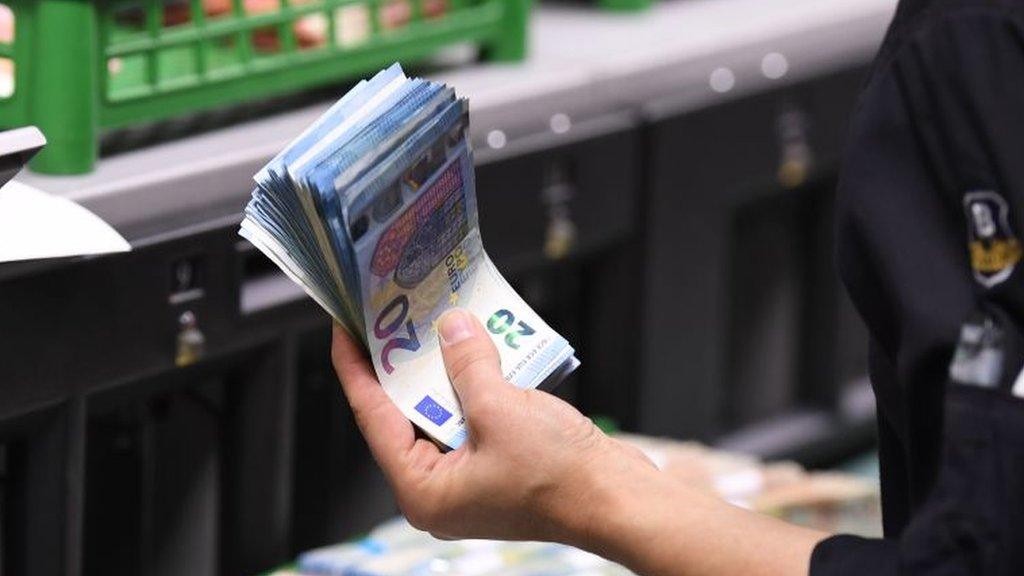 French bank employee holds euro notes