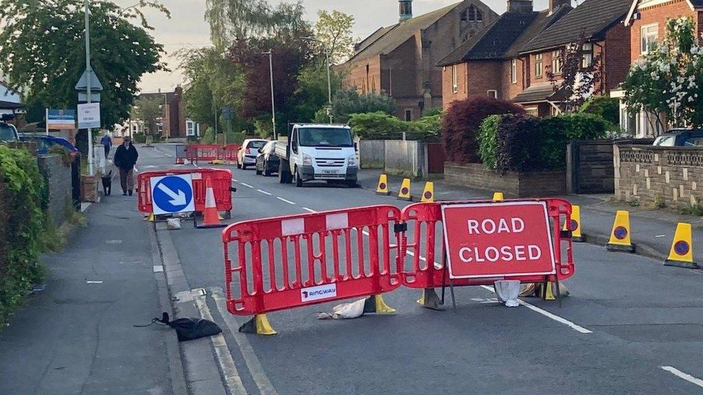 The road closed sign and traffic cones