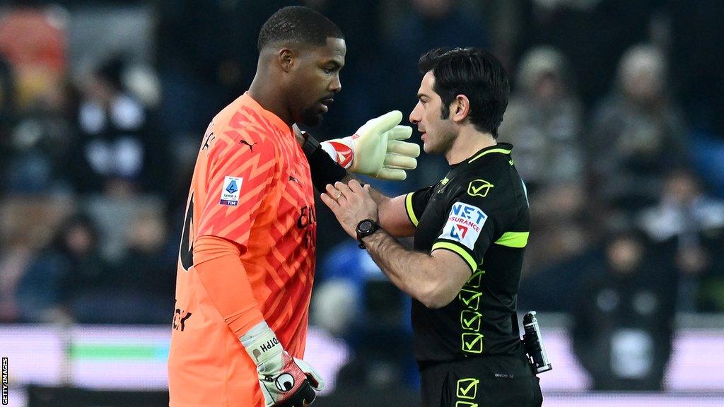 AC Milan goalkeeper Mike Maignan (left) talks to a referee