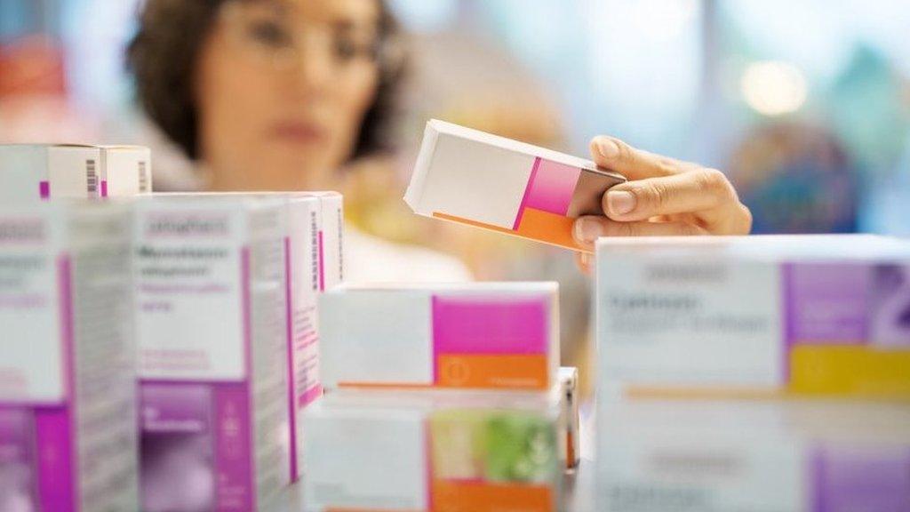 Woman looks at medicine in a cabinet