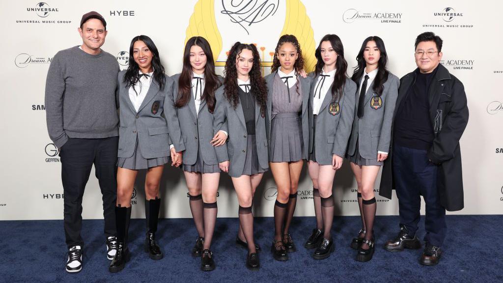 (nga e majta) John Janick (majtas), CEO i Interscope Geffen A&M Records, gjashtë anëtarët e grupit K-pop Katseye, dhe Bang Si-Hyuk, kryetar i Hybe në një konkurs talentesh reality show "The Debut: Dream Academy"  