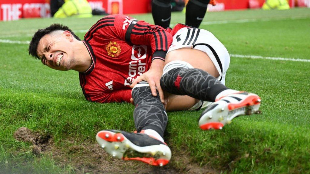 Lisandro Martinez holds his leg after picking up an injury against West Ham
