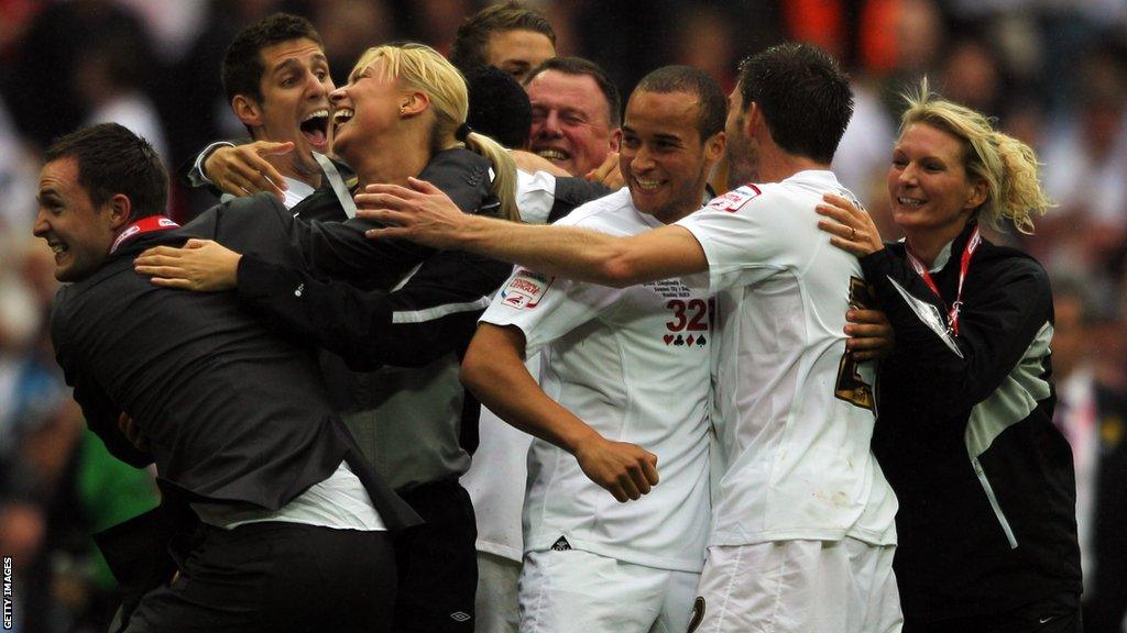 Chris Davies celebrates with players and staff on the Wembley pitch after Swansea City beat Reading in the 2011 Championship play-off final