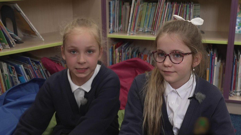 Girls sitting in library.