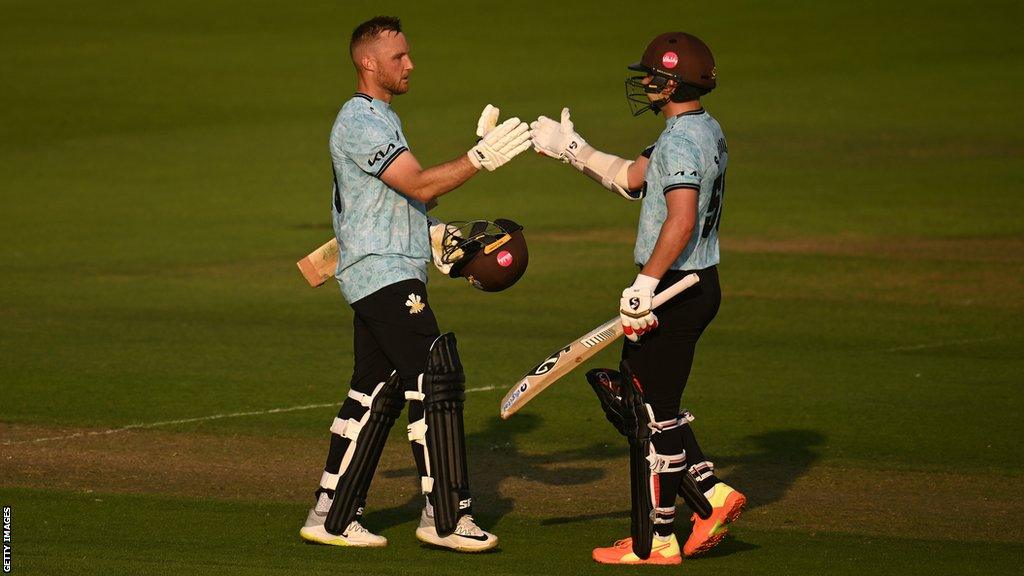 Laurie Evans is congratulated after reaching a century