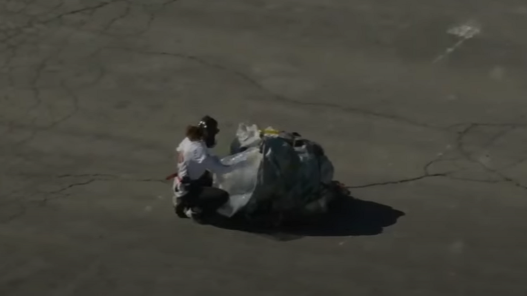 Rescue worker unwraps sample capsule after it reaches military base