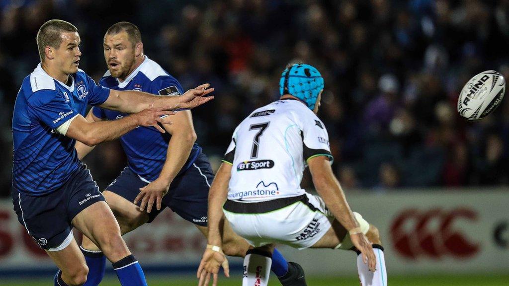 Leinster's Johnny Sexton passes as Ospreys Justin Tipuric holds the defensive line