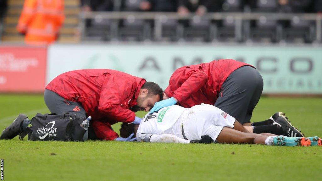 Jamal Lowe is treated on the pitch during Swansea's defeat to Southampton