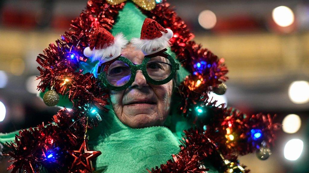 A woman dressed as a Christmas tree attends the draw at the Royal Theatre.