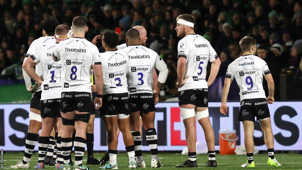 Bristol players gather around as Josh Caulfield is shown a red card by the referee