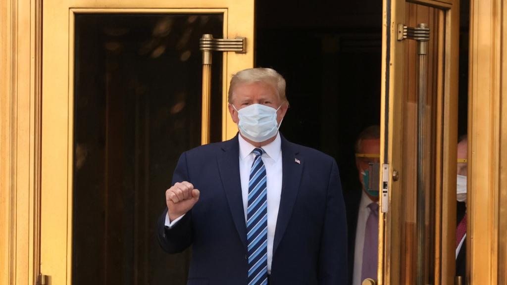 US President Donald Trump makes a fist as he walks leaves Walter Reed National Military Medical Center