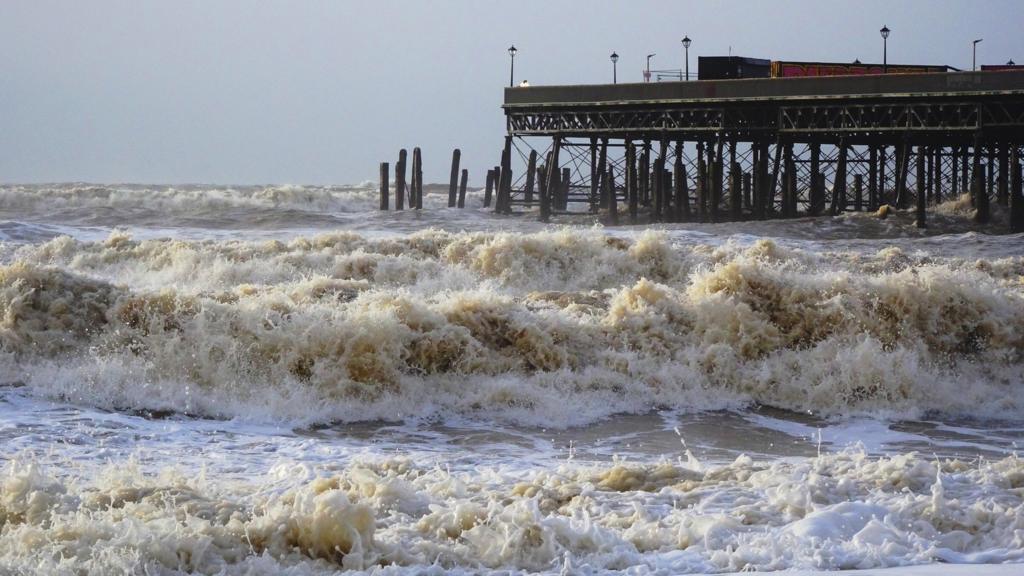 Waves crash to the beachfront in Hastings, East Sussex