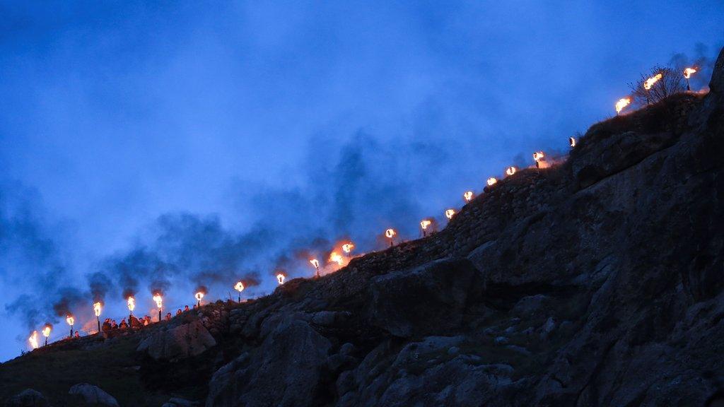 Fire torches are seen as Iraqi Kurdish people celebrate Nowruz Day, a festival marking the first day of spring and the new year, amid the spread of the coronavirus disease (COVID-19), in the town of Akra near Duhok, in Iraqi Kurdistan