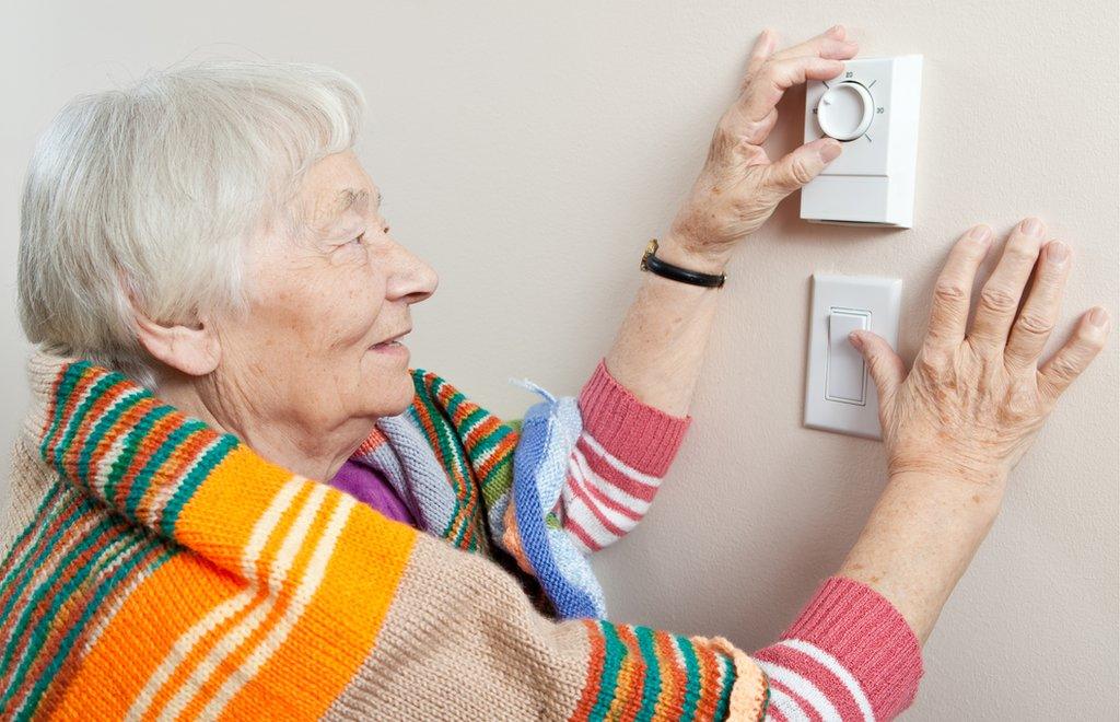 woman using thermostat