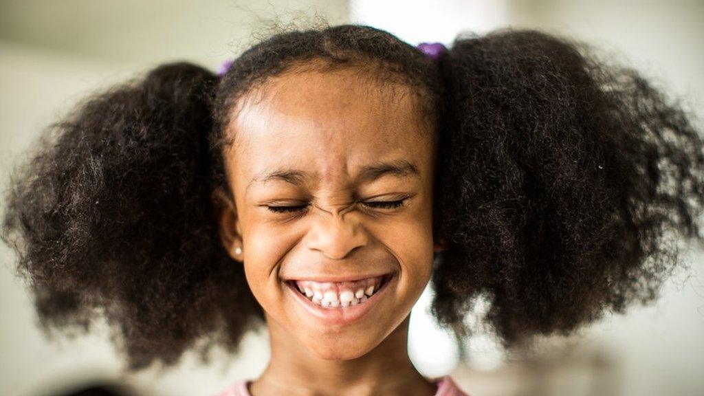girl with curly hair smiling