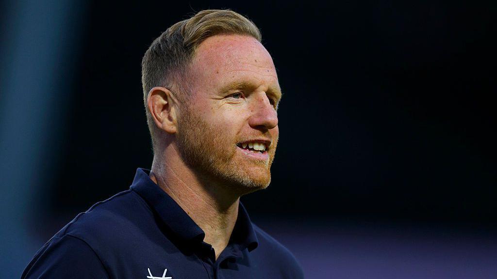 Shrewsbury Town head coach Gavin Cowan looks to the right with a smile during a pre-season game