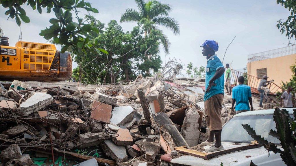 A worker surveys rubble