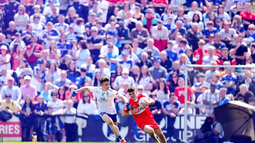 The crowd watch on as Monaghan's Luke McKenna tackles Johnny McGuckian of Derry