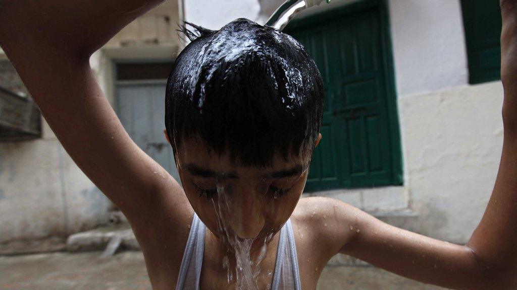 boy in Pakistan pouring water over his head