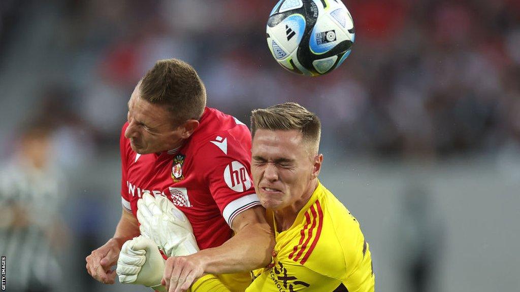 Manchester United goalkeeper Nathan Bishop collides with Wrexham's Paul Mullin